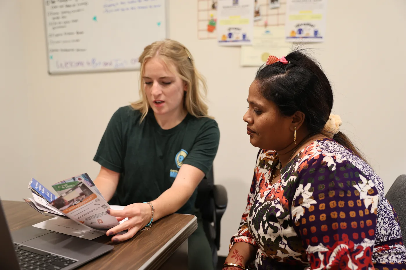 A CNMC caseworker helping a client complete paperwork