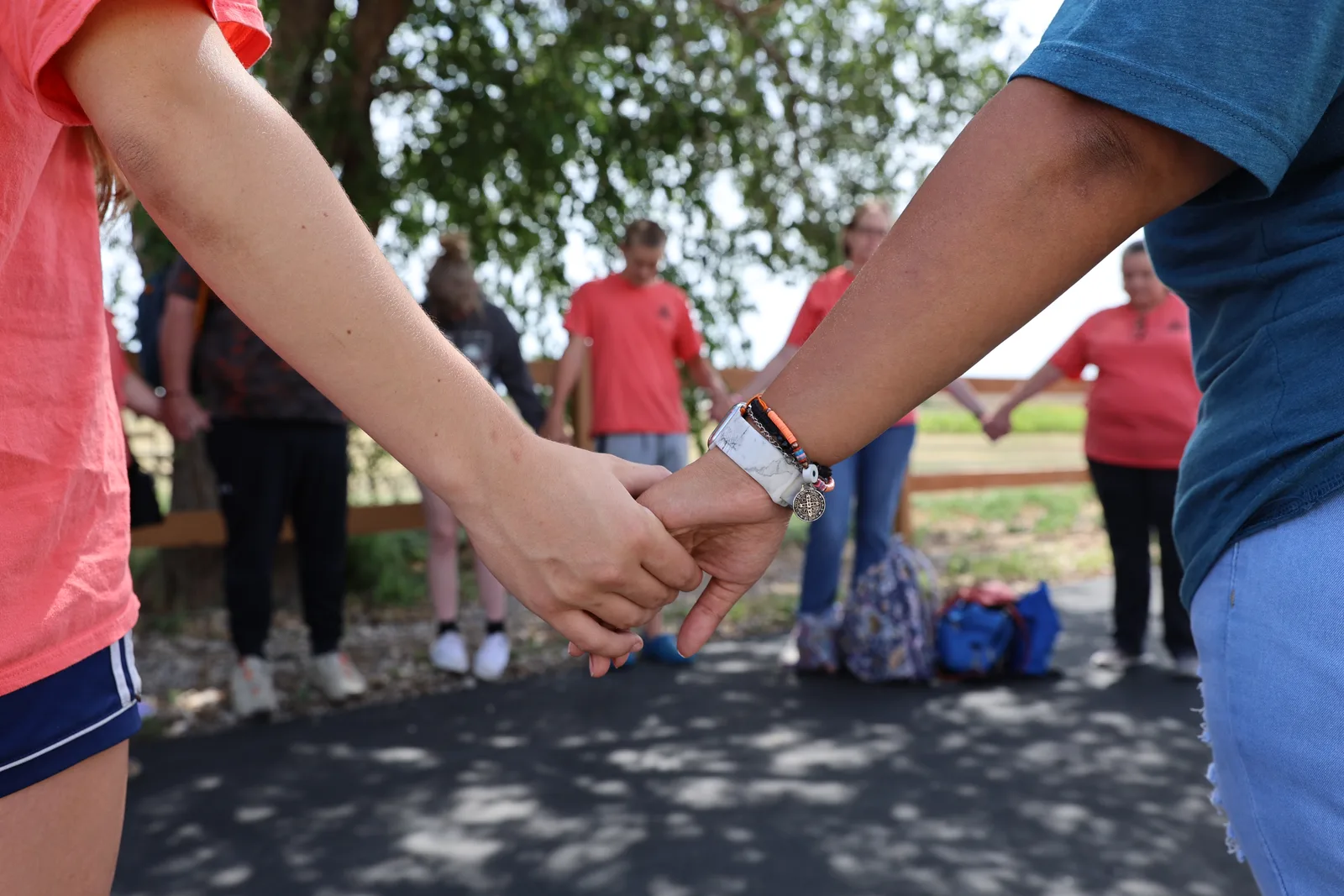 Members of the Cactus community holding hands outdoors at a CNMC gathering