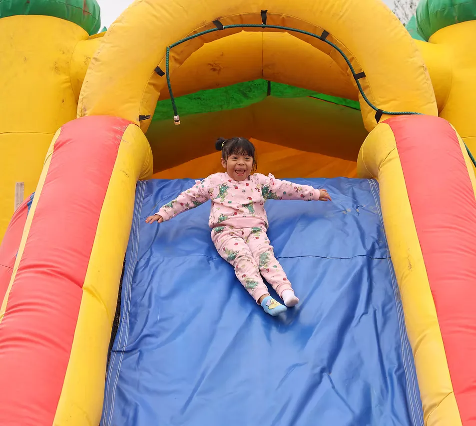 A child playing on an inflatable slide at a CNMC summer activity